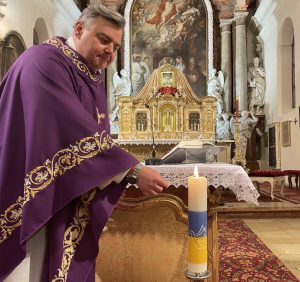 Pater Jakob Zarzycki entzündet die Ukraine-Kerze.